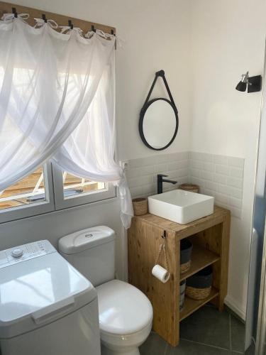 une salle de bain avec des toilettes blanches et un lavabo dans l'établissement Maison de Vacances Bassin d'Arcachon, à Gujan-Mestras