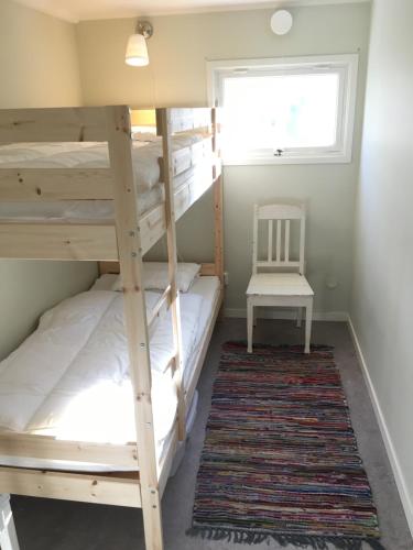 a room with two bunk beds and a chair at Trädgårdsstugan på Malingsbo herrgård in Malingsbo