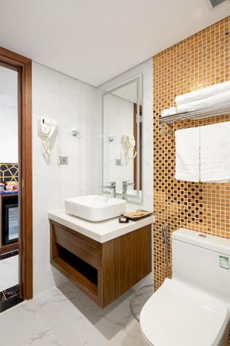 a bathroom with a white sink and a toilet at CN Palace Boutique Hotel & Spa in Danang