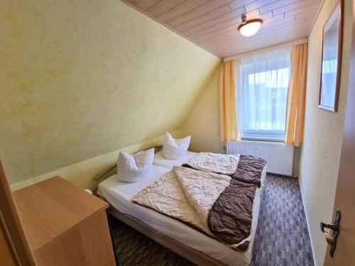ein kleines Zimmer mit einem Bett und einem Fenster in der Unterkunft Ferienwohnung Seestern Ückeritz in Ückeritz