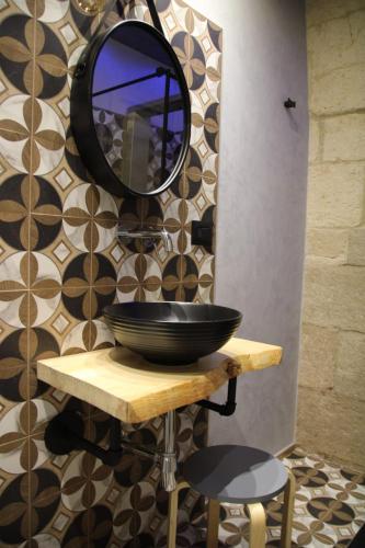 a bowl on a table with a mirror on a wall at La Dimora del Principe-Piano terra in Trani