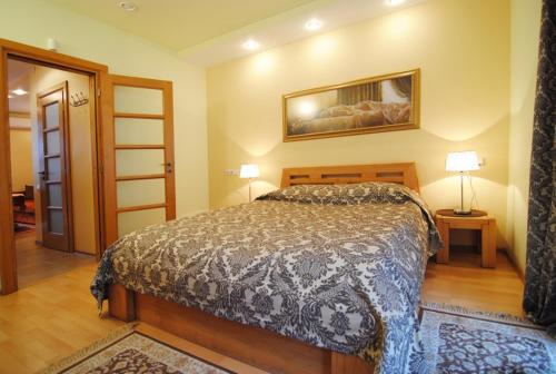 a bedroom with a bed and a picture on the wall at Saulės Krantas in Palanga