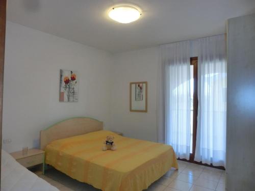 a bedroom with a bed with a teddy bear on it at Residence Leopardi - Gemini in Bibione