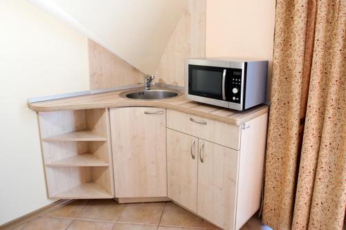 a kitchen with a sink and a microwave on a counter at Saulės Krantas in Palanga