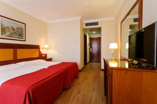 a hotel room with a bed and a flat screen tv at Gran Hotel de Ferrol in Ferrol