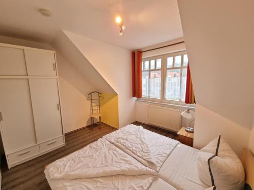 a bedroom with a white bed and a window at Ferienapartment Usedom in Ostseebad Koserow