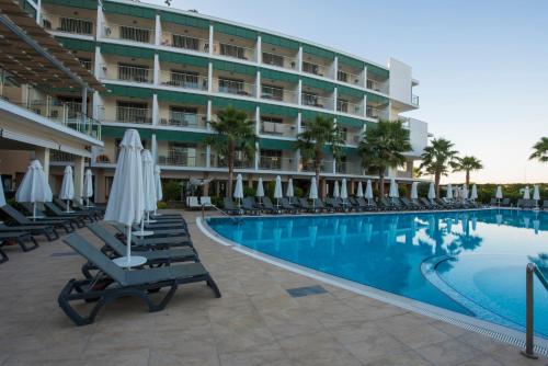 a hotel with a swimming pool with chairs and umbrellas at TUI Blue Barut Andız - All Inclusive - Adults Only in Side