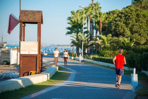 two people running down a road with palm trees at TUI Blue Barut Andız - All Inclusive - Adults Only in Side