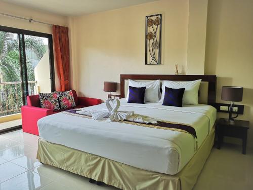een slaapkamer met een groot bed en een rode bank bij Seven Seas Hotel in Patong Beach