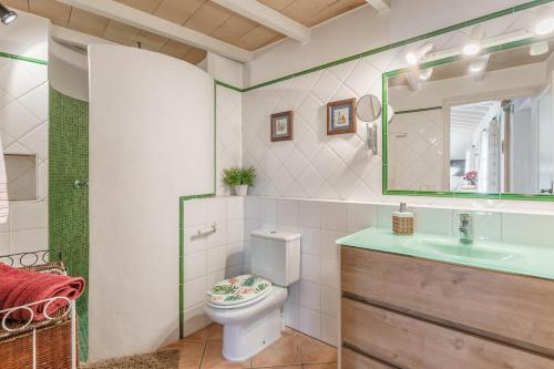y baño con aseo, lavabo y espejo. en Ca Ses Nines, en Puerto de Andratx