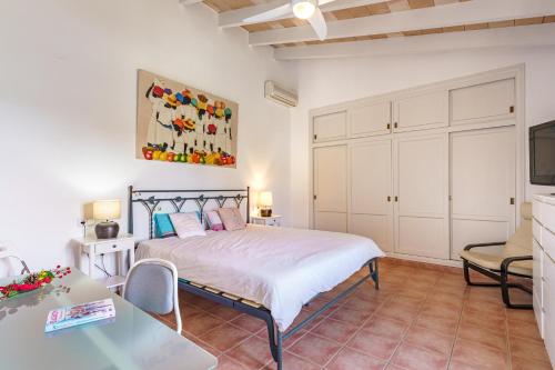 a bedroom with a bed and a table and a tv at Ca Ses Nines in Port d’Andratx