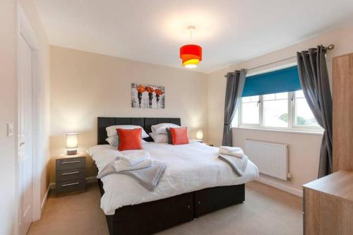 a bedroom with a large bed with red pillows at Apartment 4 in Worksop