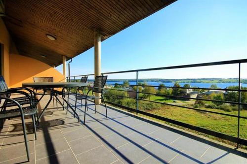 d'un balcon avec une table et des chaises et une vue sur l'eau. dans l'établissement Lacs de l'eau d'heure Amiral 24, à Erpion