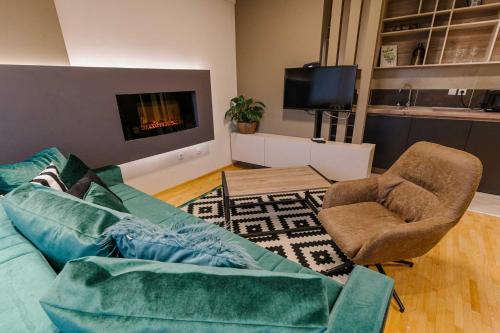 a living room with a couch and chairs and a tv at NAR Royalton Accommodation in Niš