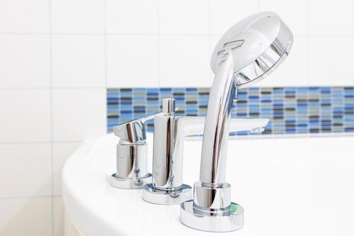 a bathroom sink with a chrome bathroom faucet at Hotel Kolumbs in Liepāja