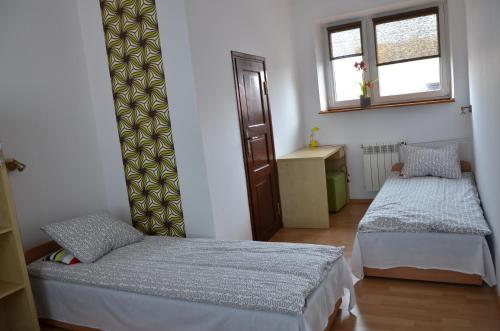 ワルシャワにあるApartament Tolekのベッド2台と窓が備わる客室です。