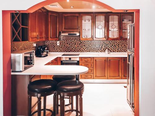 a kitchen with wooden cabinets and a counter with stools at JBR Jumeirah beach SADAF6 sea view in Dubai