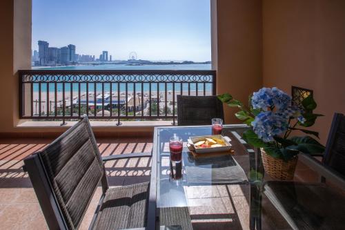 a glass table with a plate of food on a balcony at Harmony Vacation Homes - South Residence in Dubai