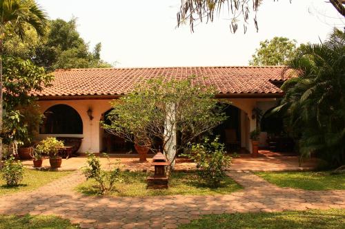 a house with a tile roof and a walkway at Secret Garden Chiangmai in San Kamphaeng