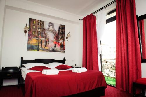 1 dormitorio con cama roja y cortinas rojas en Pensiunea Maria, en Roşiori de Vede