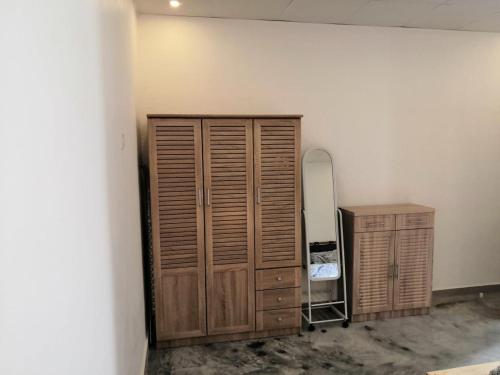 a room with a wooden cabinet and a mirror at The Blue Gate 2 in Muscat