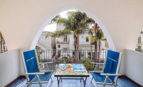 una mesa y sillas en un balcón con un arco en Hotel Terme Oriente - Beach & SPA en Ischia