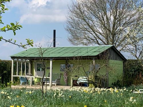 a green cottage with a green roof at The HoneyPot in Petham