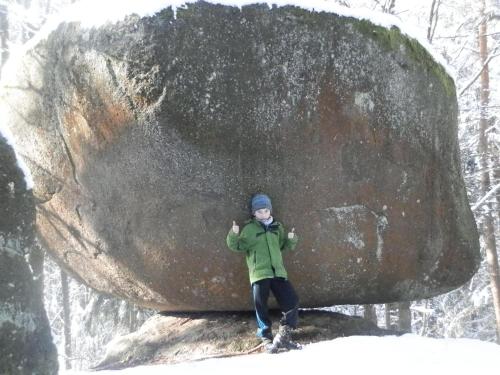 a person standing next to a large rock at Ferienwohnung Anita Benz in Thurmansbang