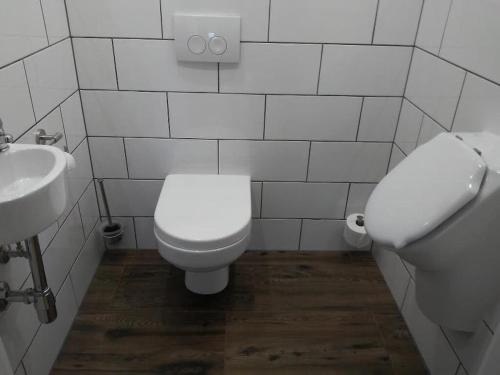 a white bathroom with a toilet and a sink at Ferienwohnung Anita Benz in Thurmansbang