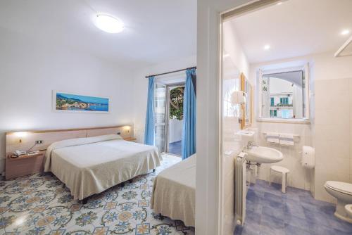 a hotel room with a bed and a bathroom at Hotel Terme Oriente - Beach & SPA in Ischia