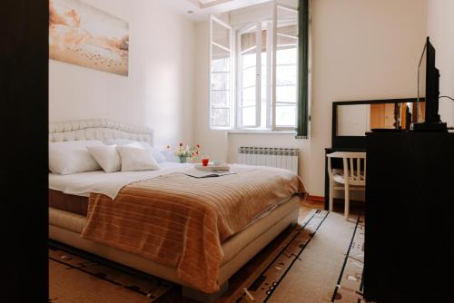 a bedroom with a large bed and a window at Apartman Milenijum in Belgrade