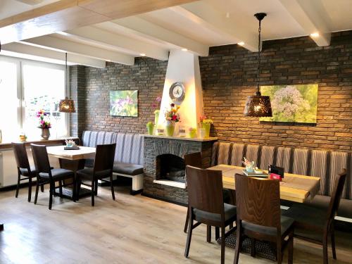 a restaurant with tables and chairs and a fireplace at Hotel Pfennigskrug in Herford