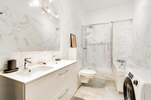 une salle de bain blanche avec un lavabo et des toilettes dans l'établissement Chic apartment - 2BR-5P - Boulevard Saint-Germain, à Paris