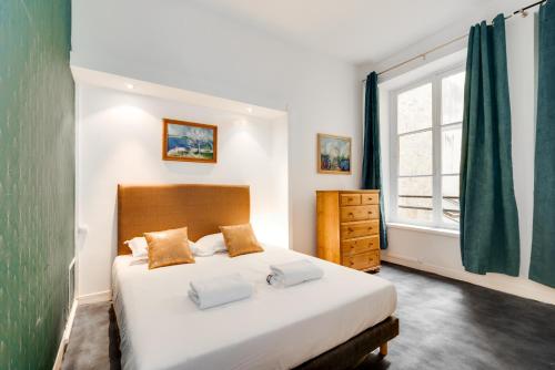 une chambre avec un grand lit et une fenêtre dans l'établissement Chic apartment - 2BR-5P - Boulevard Saint-Germain, à Paris