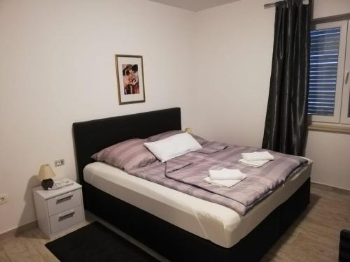 1 dormitorio con 1 cama con sábanas moradas y almohadas blancas en Vivi holiday house for 4 people, en Nerezine