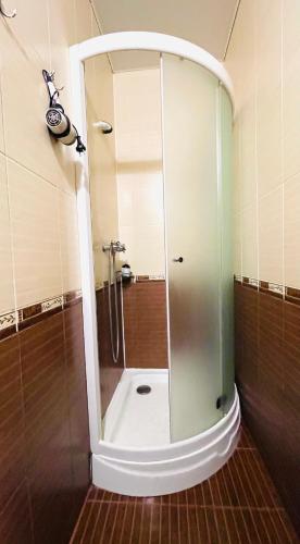 La salle de bains est pourvue d'une douche avec une porte en verre. dans l'établissement Апартаменты возле Вокзала, Центр, проспект Дмитрия Яворницкого, à Dnipro