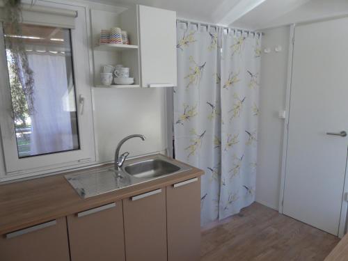 a kitchen with a sink and a shower curtain at Adriatic Blue Coast Mobile Home in Jezera