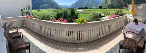 a balcony with a table and chairs and a garden at Haus Martina in Sand in Taufers
