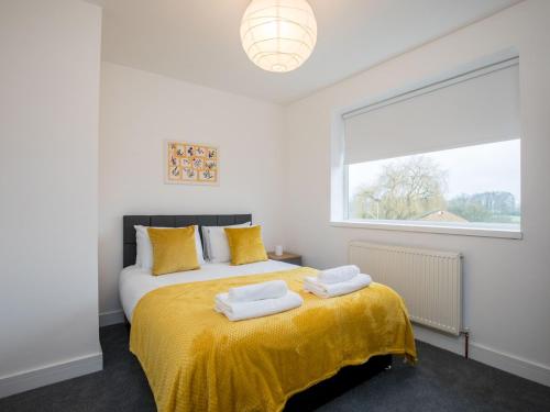 a bedroom with a bed with yellow sheets and a window at Pass the Keys Fabulous 6 Sleeper Great Location in Windsor