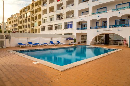 a swimming pool in front of a building at cantinho do mar in Albufeira