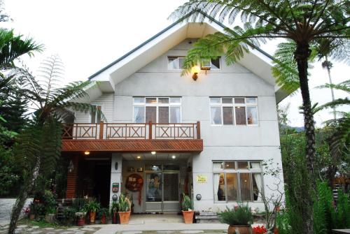 a white house with palm trees in front of it at Goose House in Yung-an-ts'un