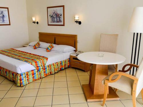 a hotel room with a bed and a table and a table at Siva Sharm Resort & SPA in Sharm El Sheikh