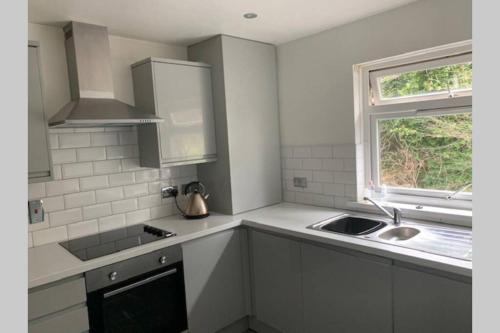 a white kitchen with a sink and a window at Spacious Durham City Centre Riverside Apartment in Durham