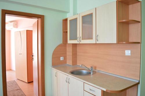 una cocina con armarios blancos y fregadero en Family Hotel Coral, en Sozopol