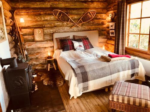 una camera con un letto in una baita di tronchi di The Swiss hut 30 minutes from Copenhagen a Kvistgård