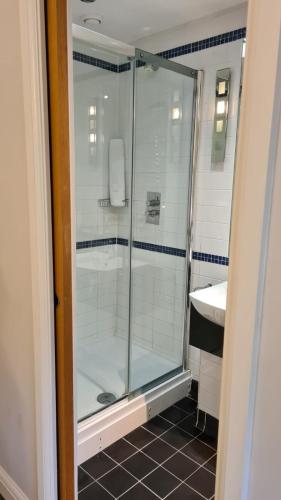 a bathroom with a glass shower and a sink at Legends Hotel in Brighton & Hove