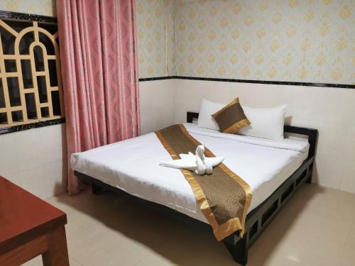 un dormitorio con una cama con un animal de peluche en Invito Guesthouse, en Sihanoukville