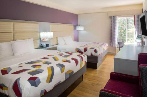 a hotel room with two beds and a desk at La Quinta by Wyndham Mobile - Daphne in Daphne