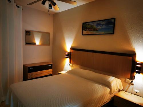 ein Hotelzimmer mit einem Bett und zwei Leuchten in der Unterkunft Rihuete in Puerto de Mazarrón