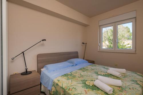 sypialnia z łóżkiem z lampką i oknem w obiekcie Apartment Manto Free Parking w Rovinj